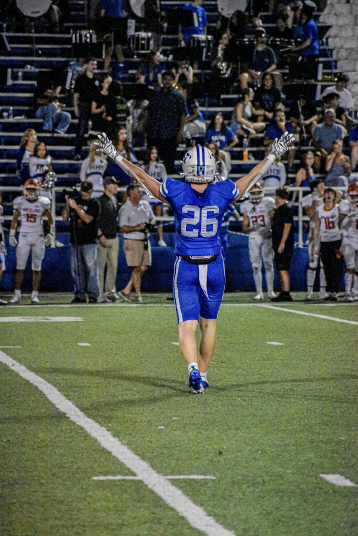 Ethan Grimm (12) turns to the crowd with his hands in the air.